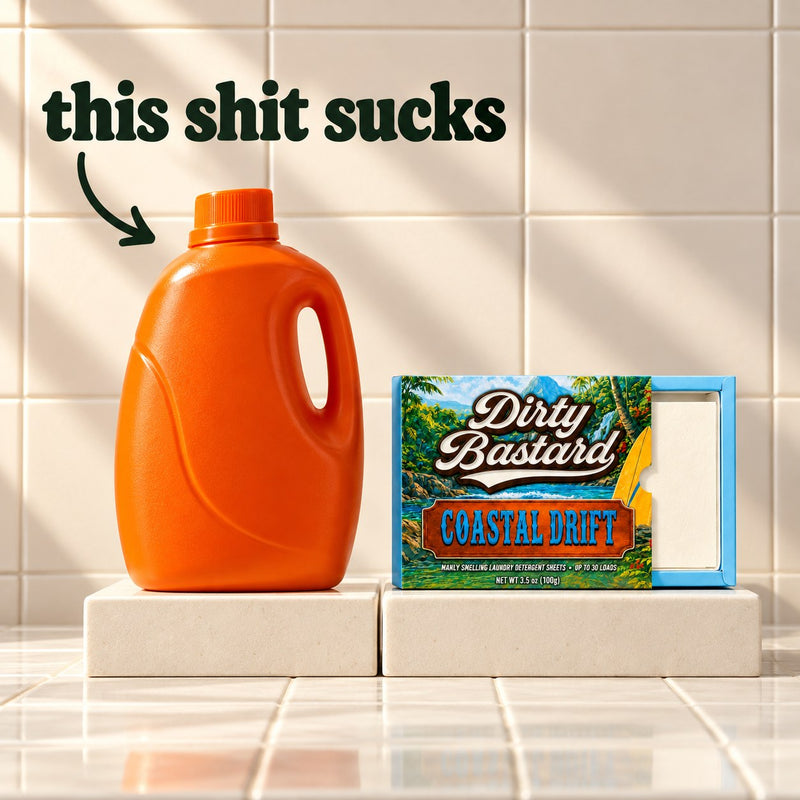 A plain orange detergent jug with an arrow and the words this shit sucks, next to a box of Dirty Bastard Coastal Drift laundry detergent sheets.